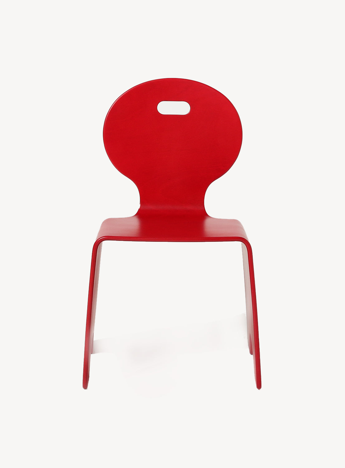 A red chair with a unique design, featuring a circular cut-out at the back and a flat seat.
