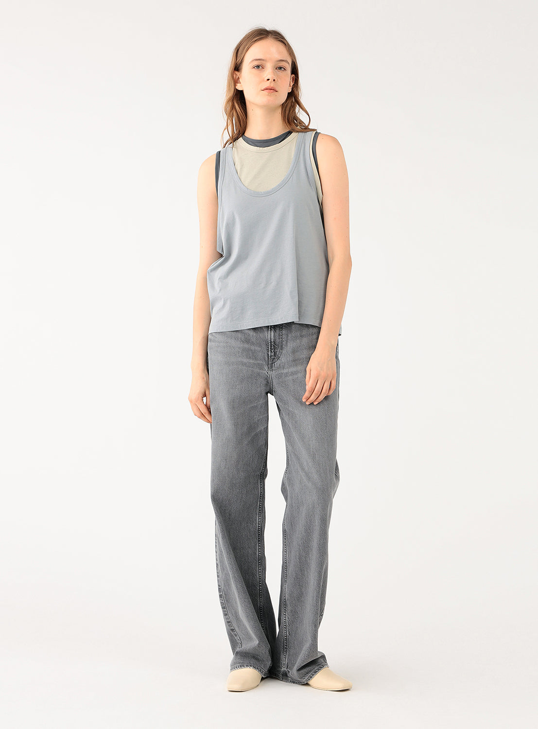 Model wearing a pair of high waisted gray jeans, styled.