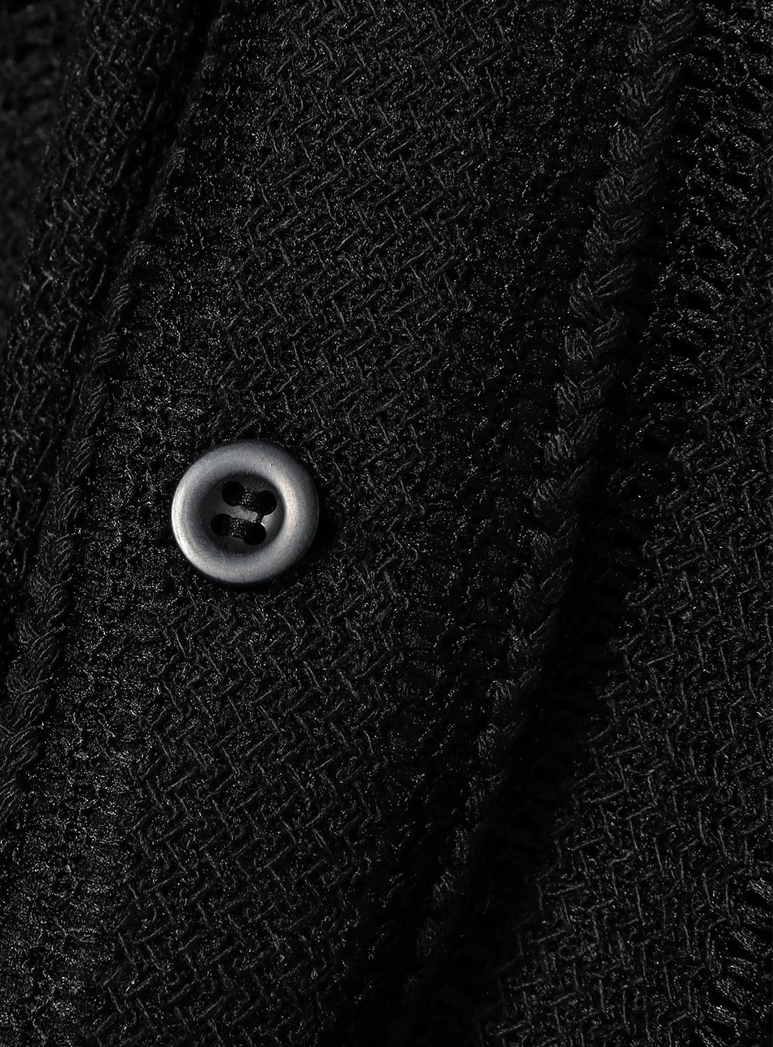 Close-up of the black shirt's fabric, showing the black button. 