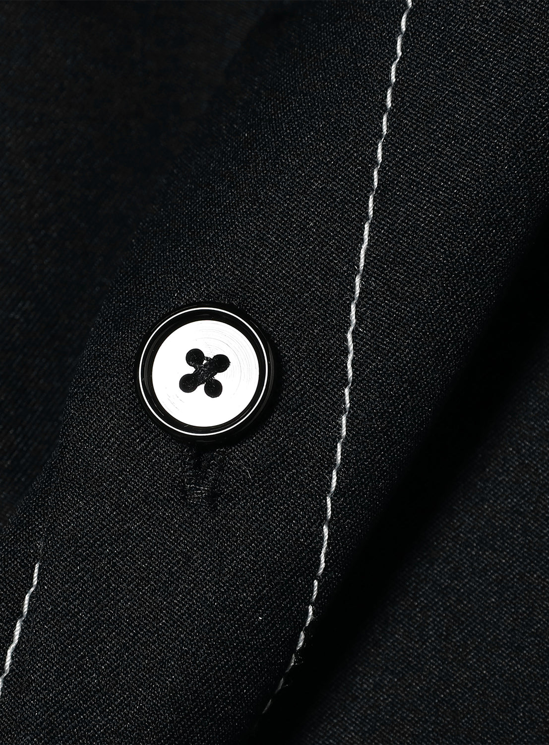 Close-up of black BEAMS Stitching Easy Shirt with matching button and white stitching, made from quick-drying polyester fabric.