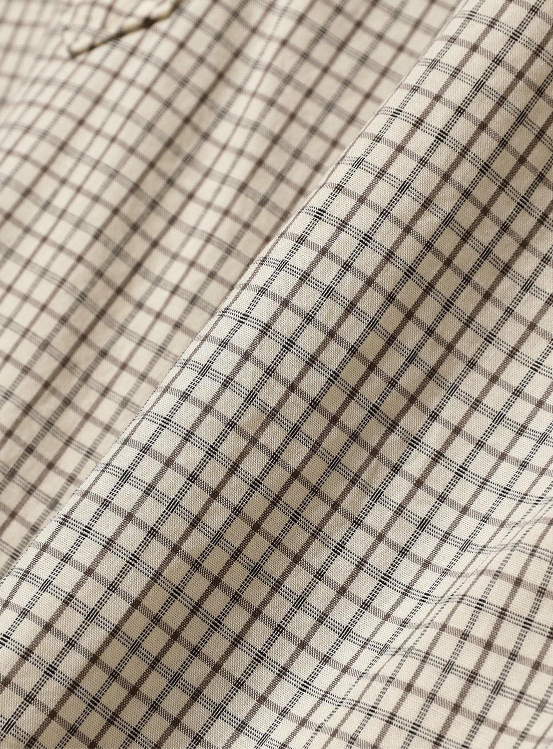 Close-up of off-white fine check-patterned typewriter cloth, revealing the subtle texture and intricate pattern.