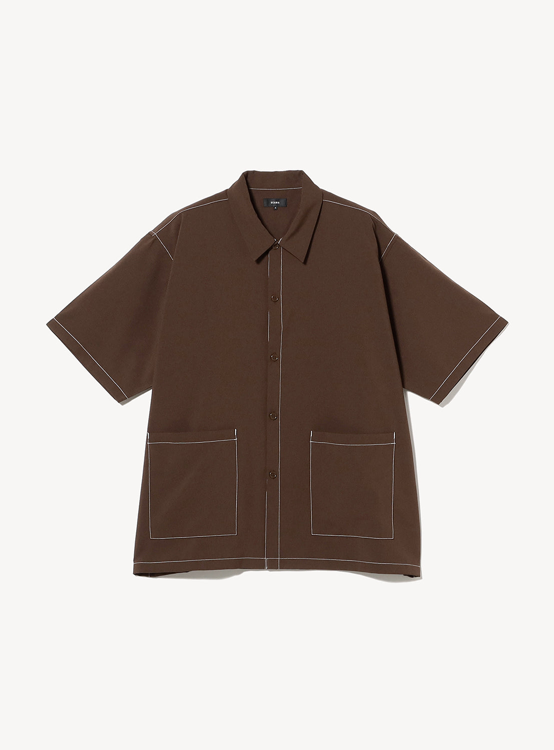 BEAMS Wide Fit Double Pocket Contrast Stitch Shirt features short sleeves, a brown hue, a comfortable wide fit for easy movement, a collared neckline, two large front pockets, and distinctive white contrast stitching along the seams and pocket edges.