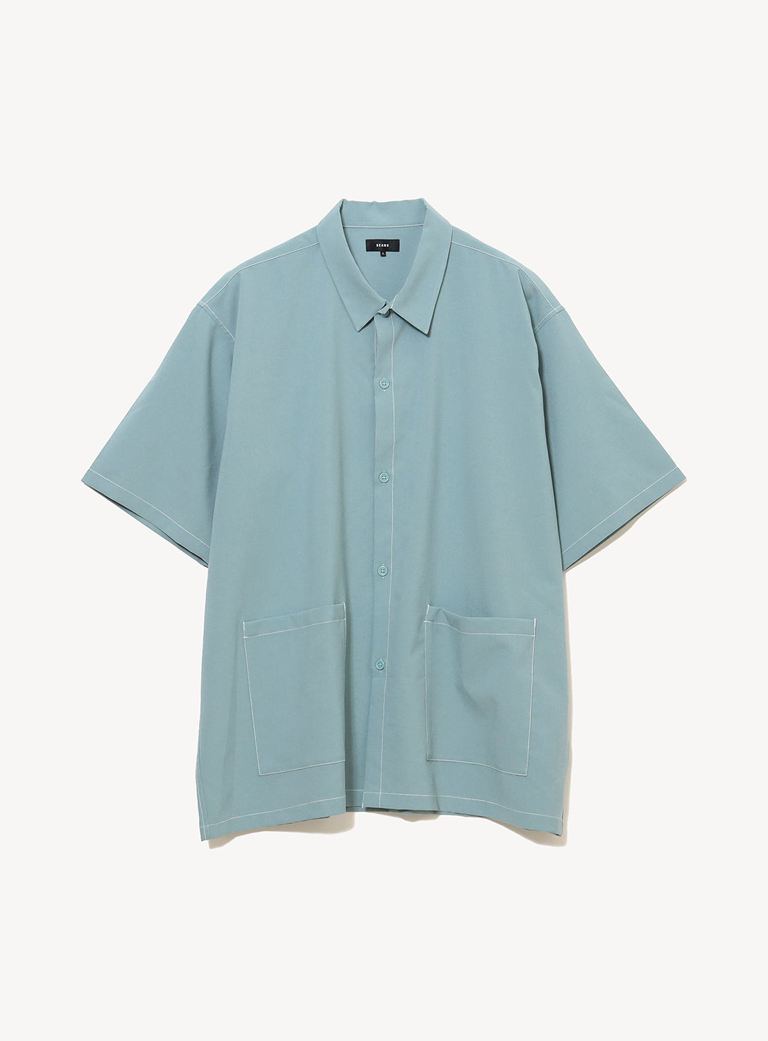 The BEAMS Wide Fit Double Pocket Contrast Stitch Shirt is a light blue, short-sleeve utility button-up featuring a collar and two spacious front pockets, crafted from moisture-wicking performance fabric and shown against a plain white background.