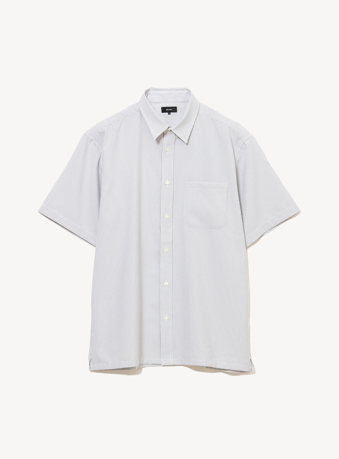 The BEAMS Stretch Quick-Dry Seersucker Relaxed Fit Shirt is a lightweight, short-sleeved shirt with light blue and white stripes, featuring a button-up front, classic collar, and chest pocket, shown against a plain white background.