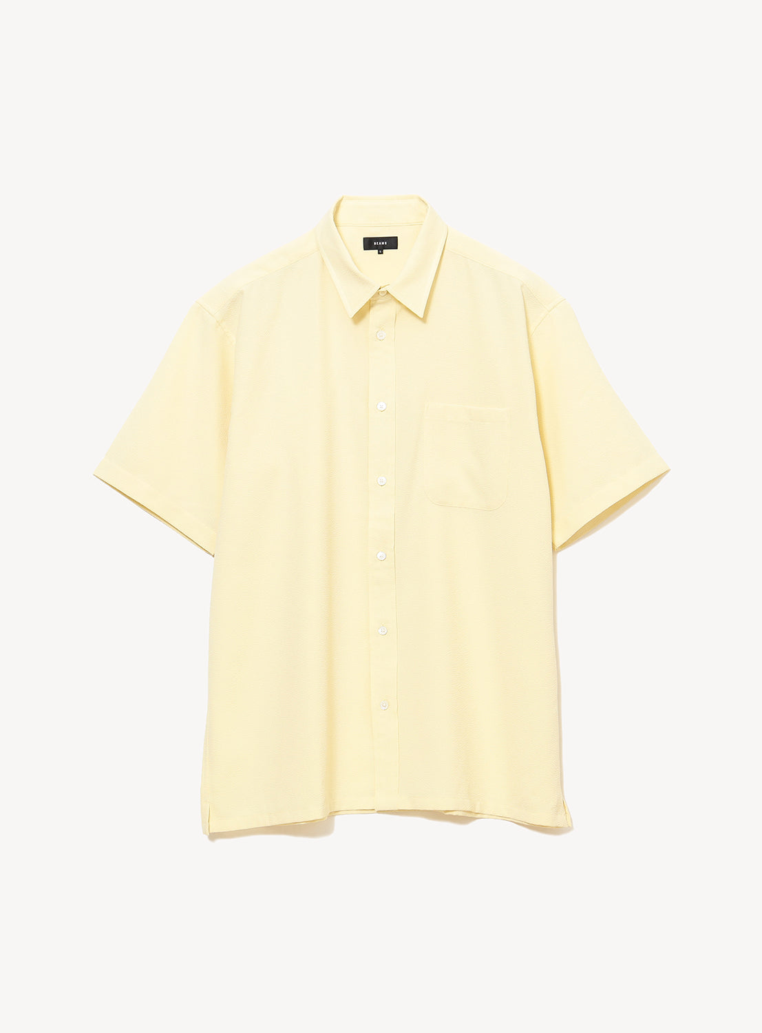 The BEAMS Stretch Quick-Dry Seersucker Relaxed Fit Shirt is a light yellow, short-sleeve top featuring a chest pocket, crafted from lightweight, wrinkle-resistant fabric and shown against a plain white background.