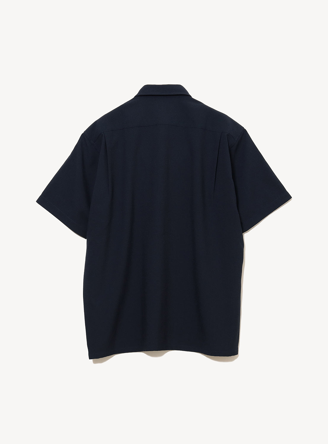 A BEAMS Stretch Quick-Dry Seersucker Relaxed Fit Shirt in dark navy, featuring short sleeves and a button-up design, is displayed flat from the back on a white background. Made from lightweight, wrinkle-resistant fabric, this shirt offers effortless style and comfort.