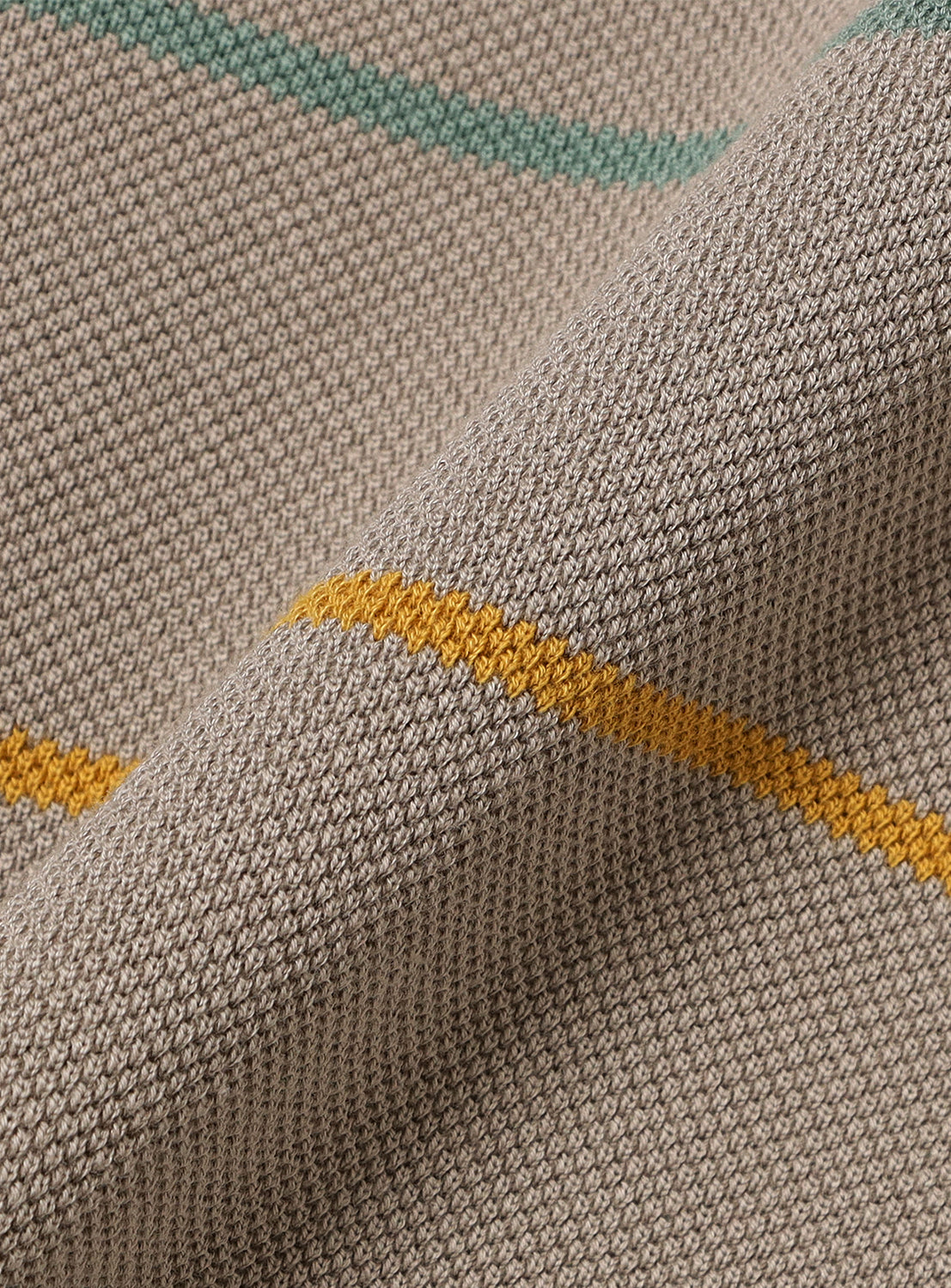 Close-up of taupe knit fabric, detailing the texture and thin yellow and green stripes.