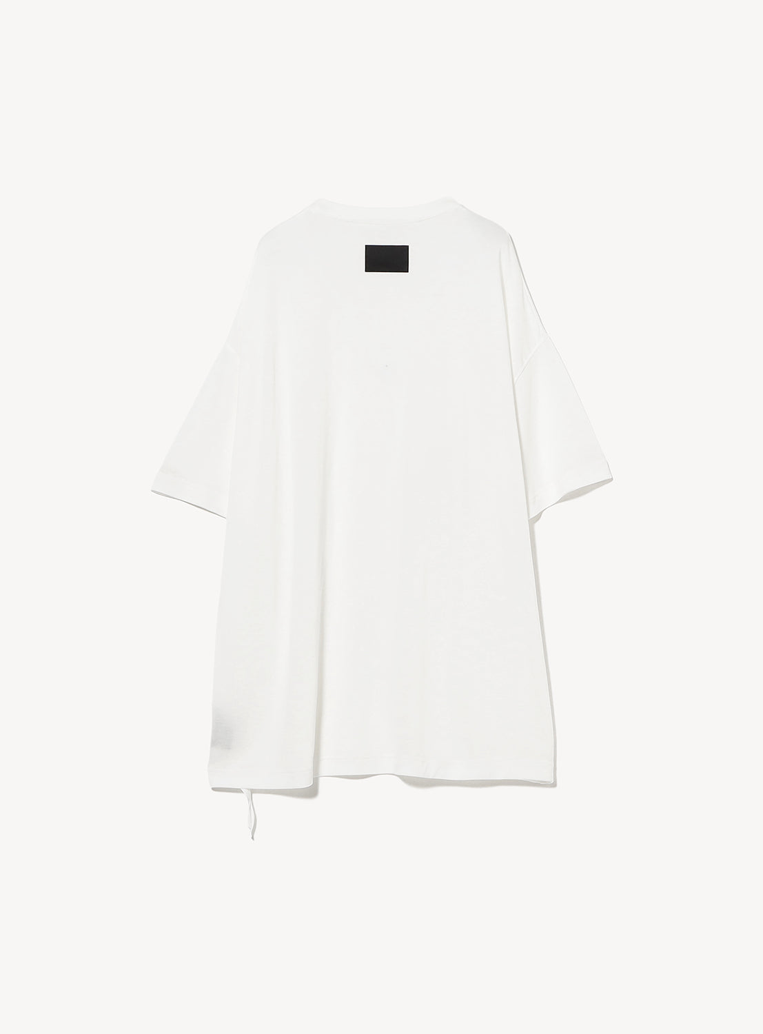 The Bowie T-Shirt by COG THE BIGSMOKE is presented in crisp white, showcased on a white background and viewed from the back. This piece features an oversized, voluminous silhouette and is accented with a small black rectangular patch near the neckline for subtle detail.