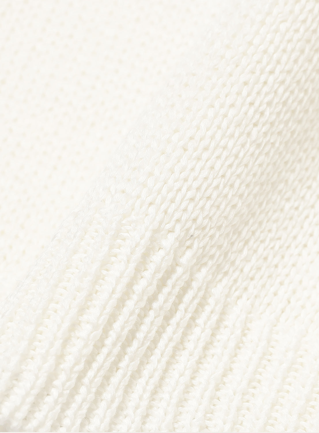 Close-up of the cream-colored material, highlighting the quality of the knit.