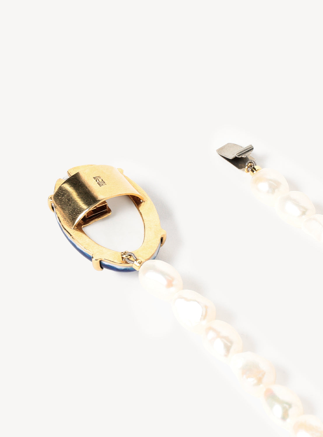 Close-up of the Hizen Jewelry Arita Ware Motif and Pearl Long Necklace: a gold oval clasp secures a strand of irregular freshwater pearls, their elegant design reminiscent of Japanese ceramic craftsmanship, displayed against a plain white background. Nearby lies a matching pearl strand accented with a silver end, part of this distinctive necklace from Hizen Jewelry.