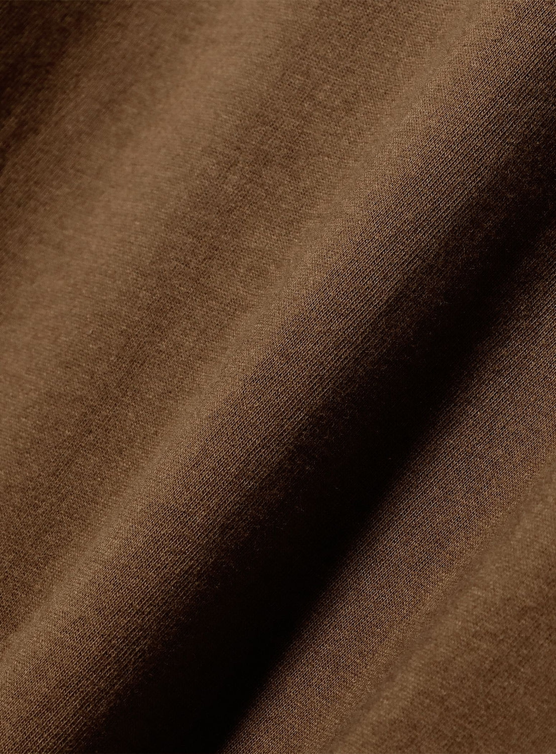 Close-up of a brown Chaos Fishing Club Tairyo Short Sleeve T-Shirt cotton fabric with diagonal folds.