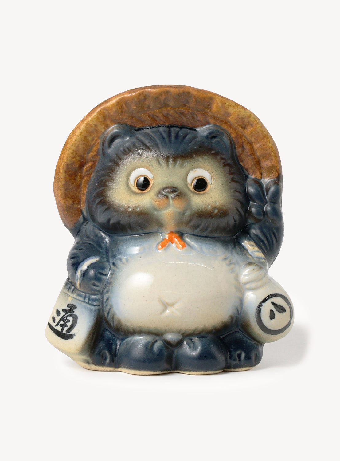 Small ceramic figurine of a cat-like creature with a wooden hat on a white background