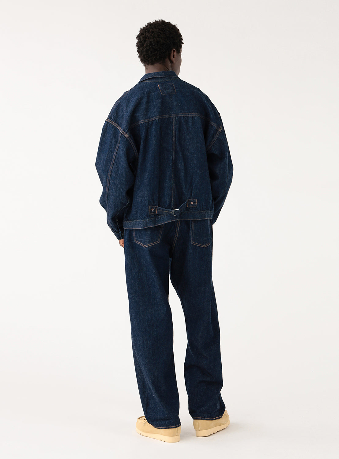 Back view of model wearing orSlow x BEAMS Type 1 selvedge denim pants with matching jacket and white T-shirt, workwear fit.