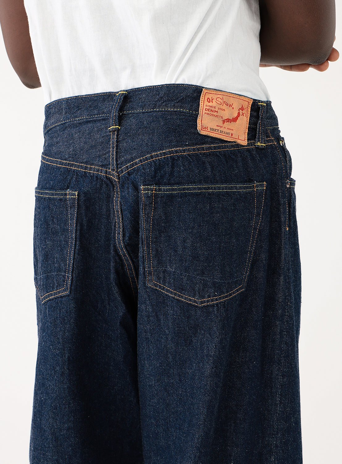 Close up of the back of Exclusive orSlow x BEAMS JAPAN 100 Super Dad jeans on a model. Relaxed fit, light-weight selvedge denim pants in classic indigo, Japanese craftsmanship, vintage-inspired wide leg silhouette.