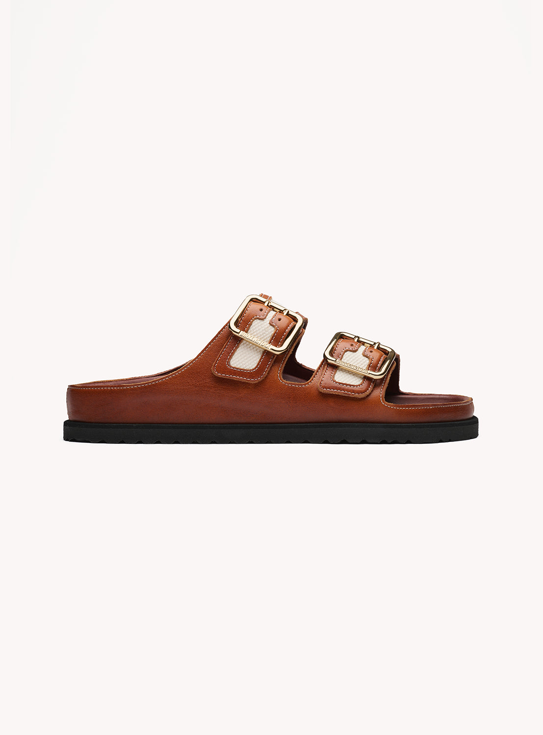 Brown sandal with gold buckles on a white background