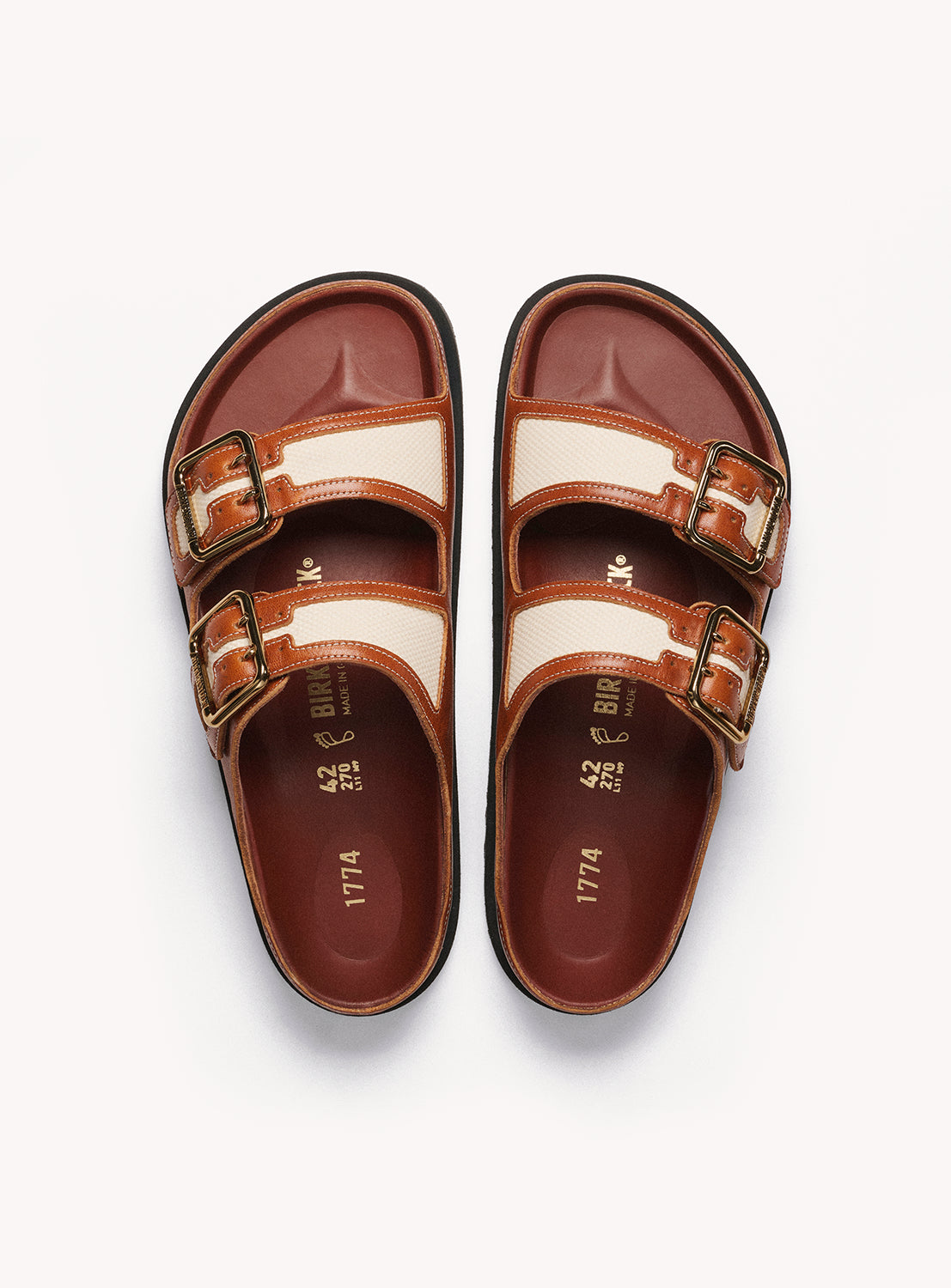 Birkenstock Pair of brown and beige sandals with buckles on a white background