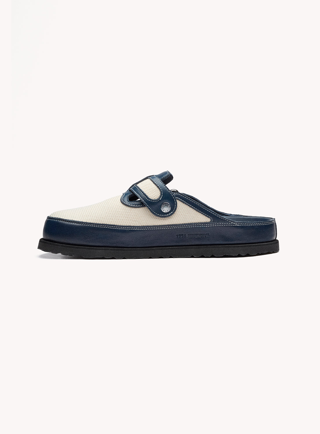 Navy and white slip-on shoe with a strap on a white background