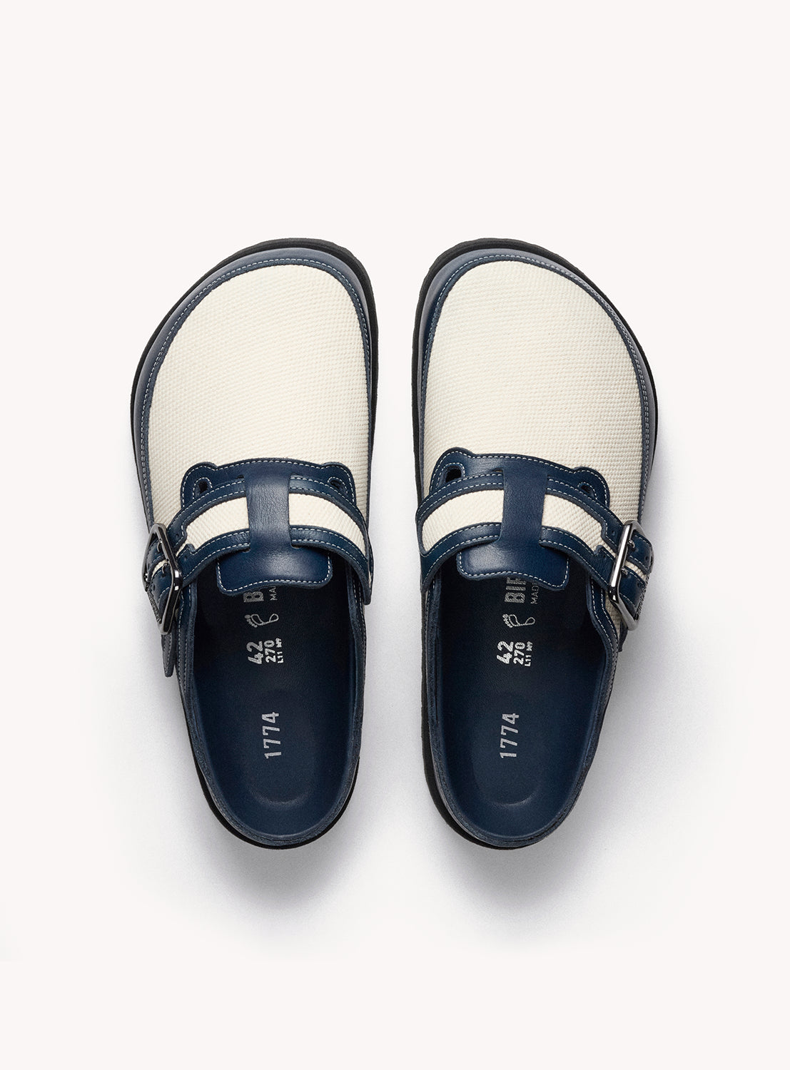Birkenstock Boston Pair of navy and white shoes with buckles on a white background