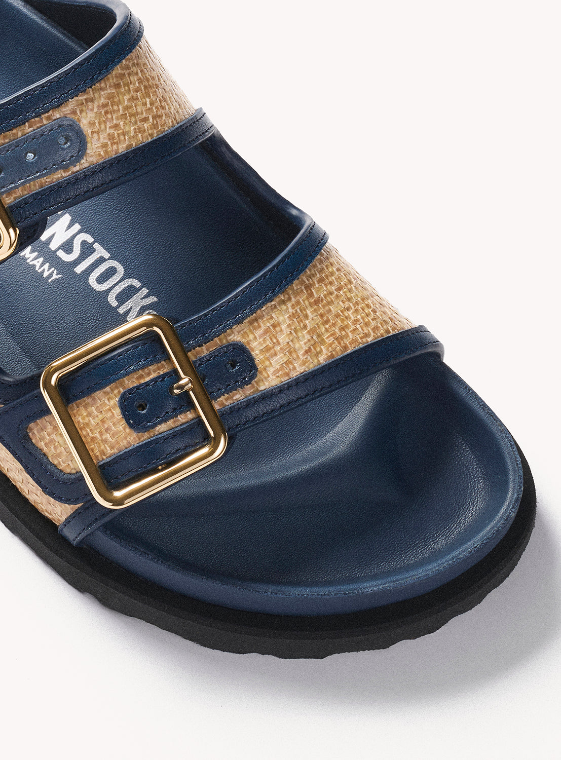 Navy sandal with a gold buckle on a white background