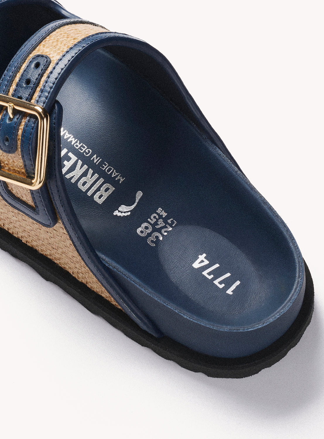 Navy sandal with cork sole and gold buckle on a white background