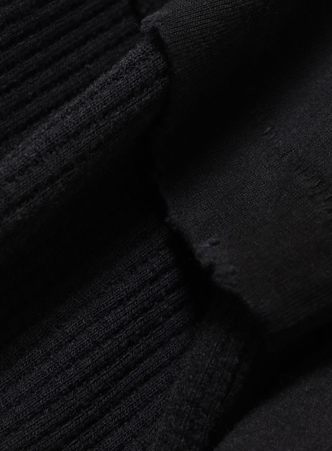Close-up of a black Vintage Layered Fade Long-Sleeve T-Shirt, showing the transition between ribbed fabric and a smooth cotton jersey cuff.