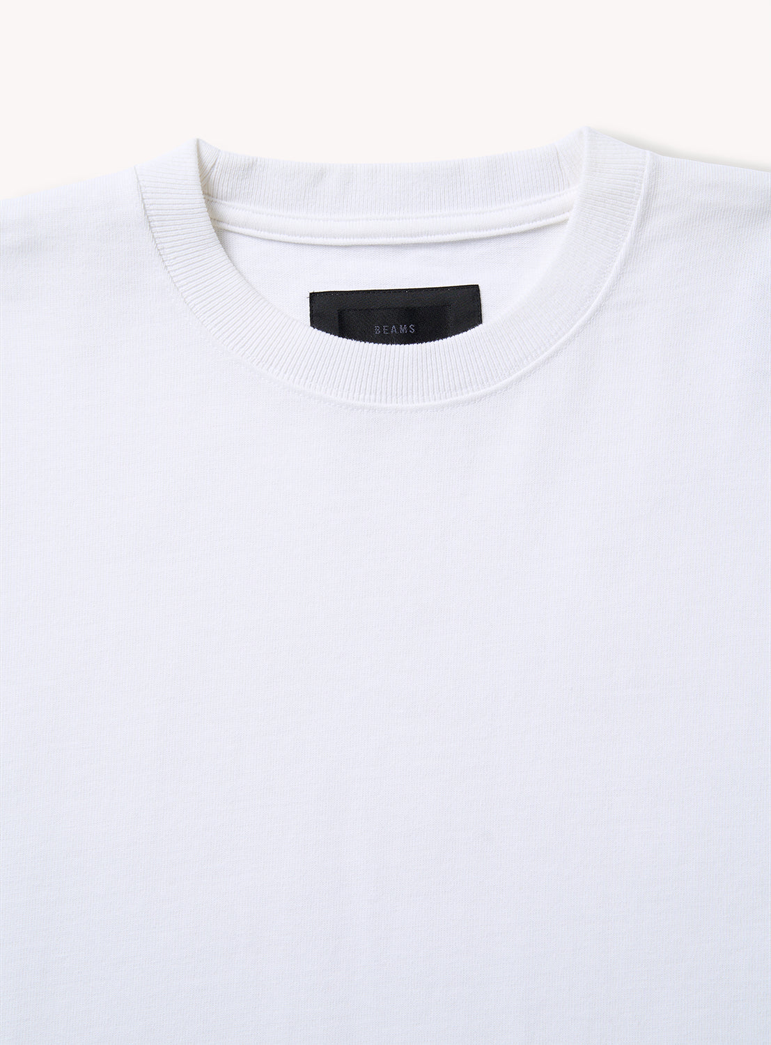 Close-up of the BEAMS A - Suvin Turi T-Shirt, highlighting its ribbed collar and black neck label. This premium tee is showcased against a neutral light background.