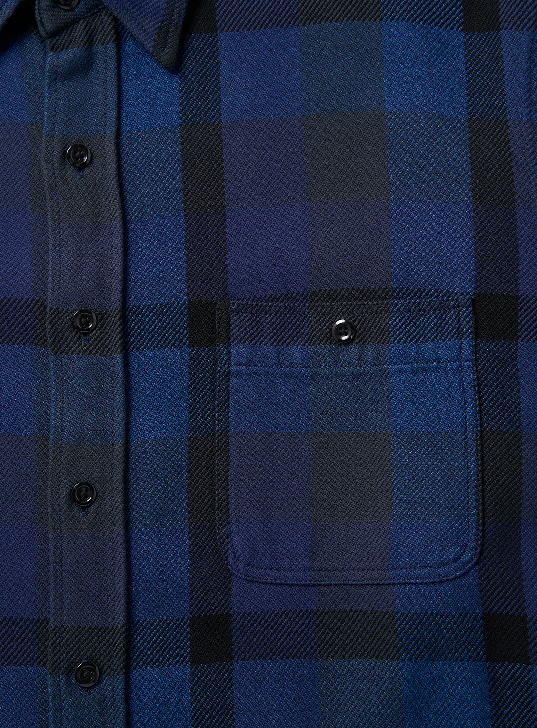Close-up of the BEAMS Indigo Check Shirt, a relaxed fit button-up in blue and black plaid, featuring black buttons and a single chest pocket with a flap and button closure.