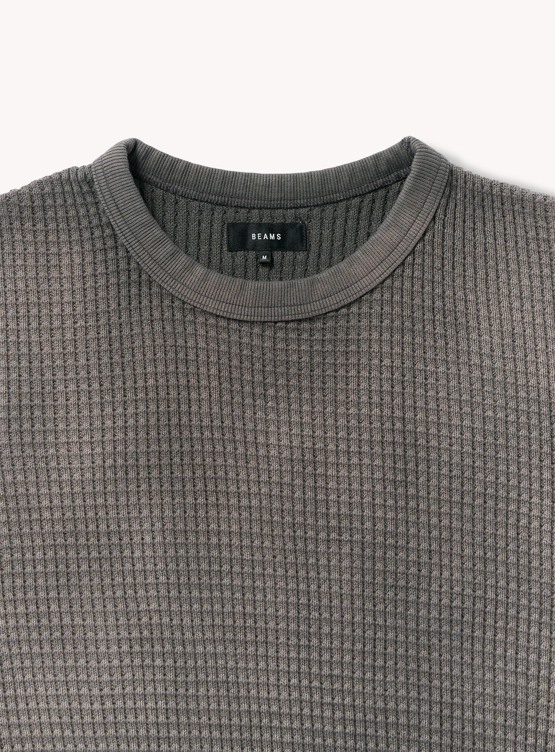 Wide Fit Faded Waffle T-Shirt by BEAMS, shown in a flat lay. This gray heavyweight waffle knit tee features a round neckline and is designed for added texture and warmth. A black label with white "BEAMS" text is sewn inside the collar, set against a plain light background.