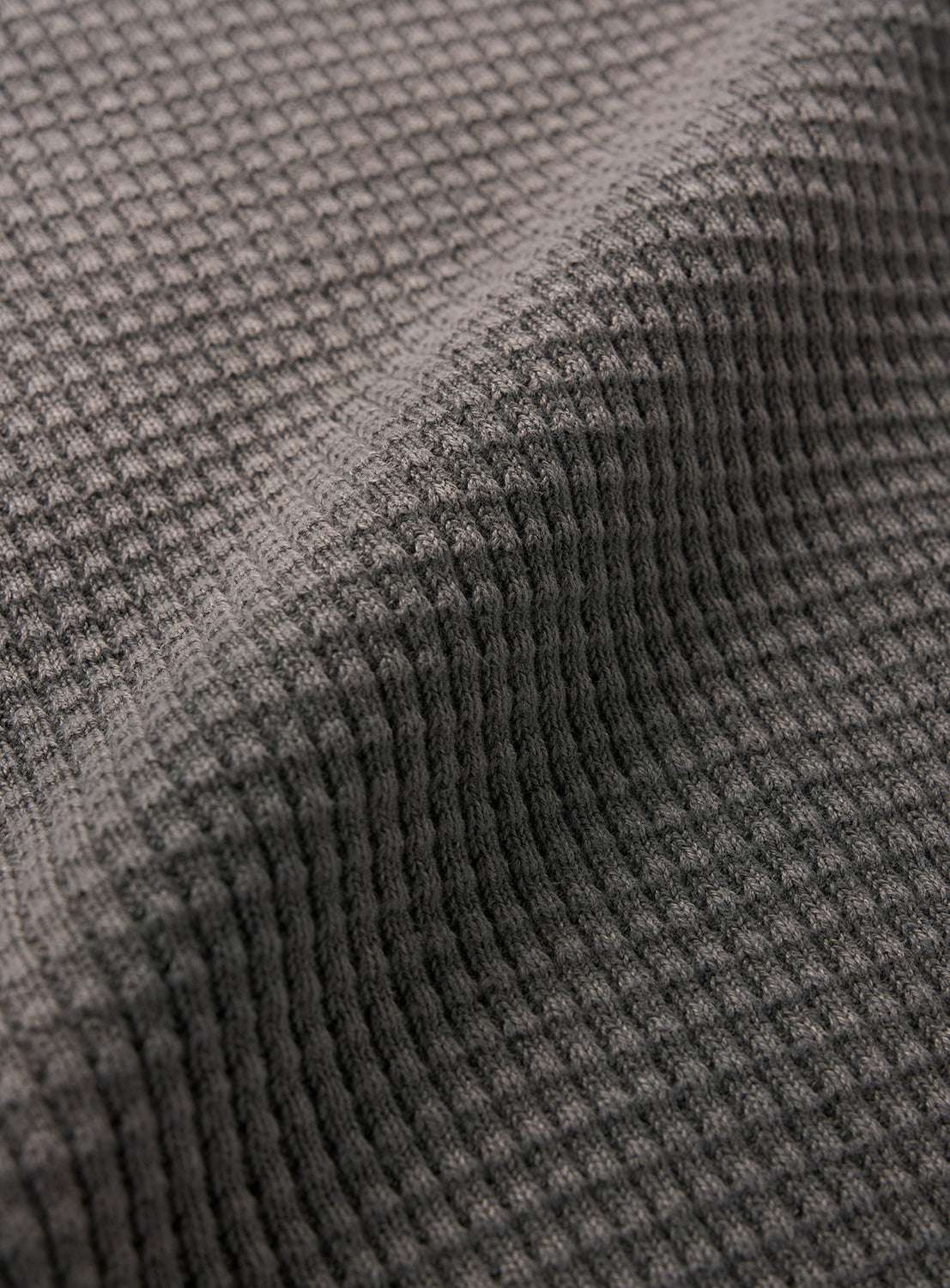 Close-up of the BEAMS Wide Fit Faded Waffle T-Shirt in textured gray fabric, featuring a heavyweight waffle knit with a grid pattern and a raised ridge running diagonally across the surface.