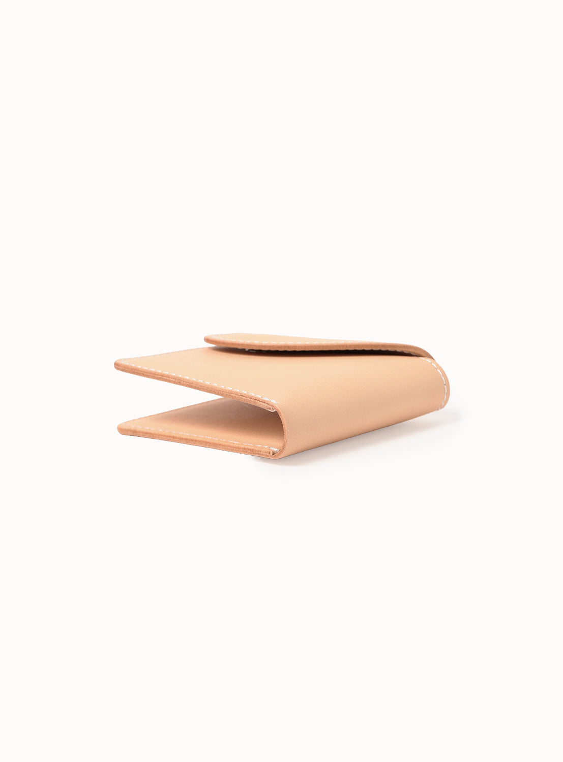 The Hender Scheme Leather Wallet, crafted in tan bridle leather, is shown partially open on a white background, highlighting its minimalist bifold design, visible edge stitching, and the natural patina forming with use.