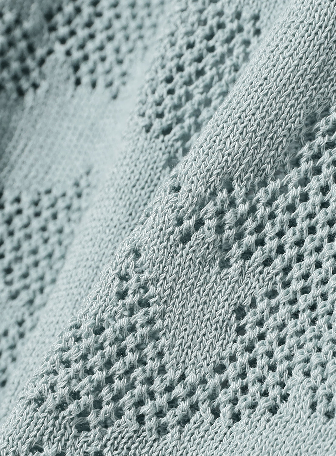 Close-up of knit textured light blue fabric.