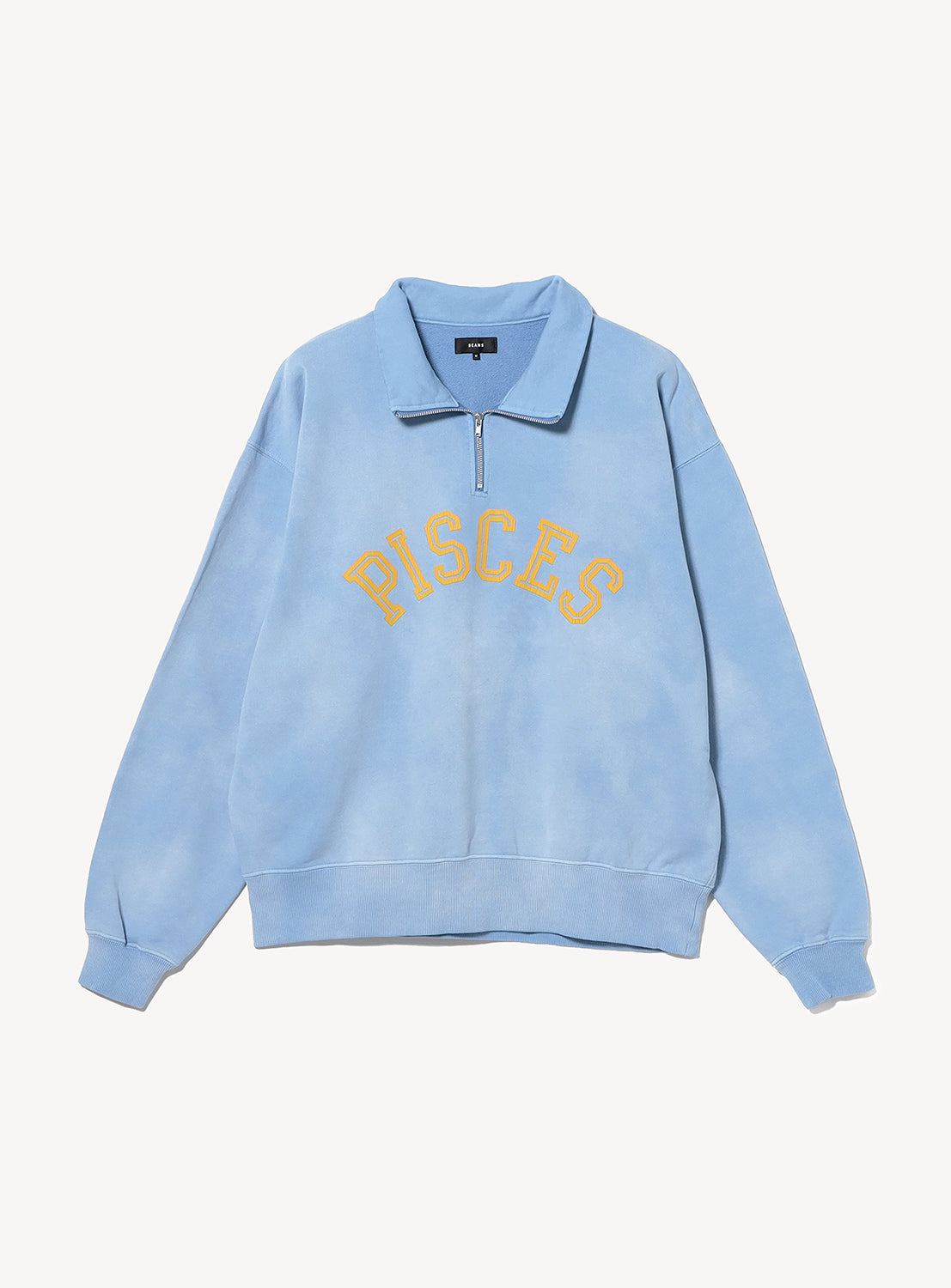 Light blue BEAMS Faded Souvenir Half Zip Pullover with a cropped fit and the word PISCES embroidered in yellow on the chest.
