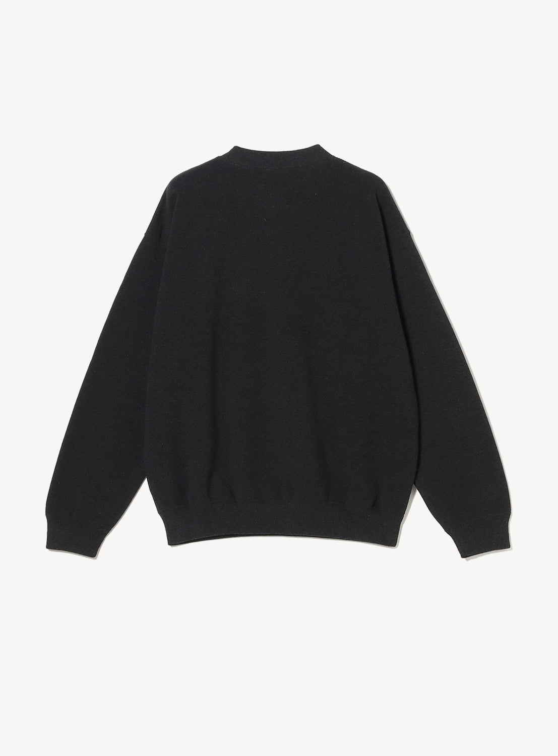 Back of a model wearing a black crew neck sweater on a white background. 
