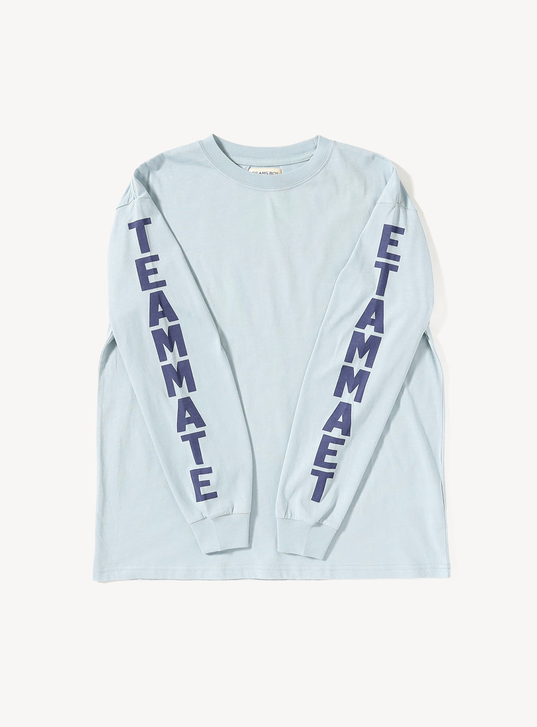 The BEAMS BOY Big Logo Long-Sleeve T-Shirt is a light blue top with an easygoing, relaxed fit, featuring bold dark blue “TEAMMATE” lettering printed vertically down both sleeves for a standout look.