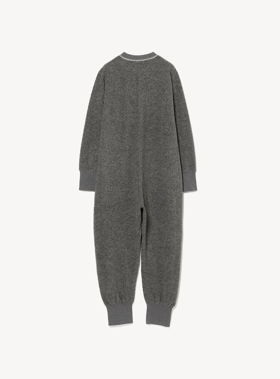 A long-sleeved, full-length grey Knit Jumpsuit by THE BASIC, featuring ribbed cuffs at the wrists and ankles. Shown from the back against a plain white background, this one-piece is a true wardrobe staple designed for comfort and style.