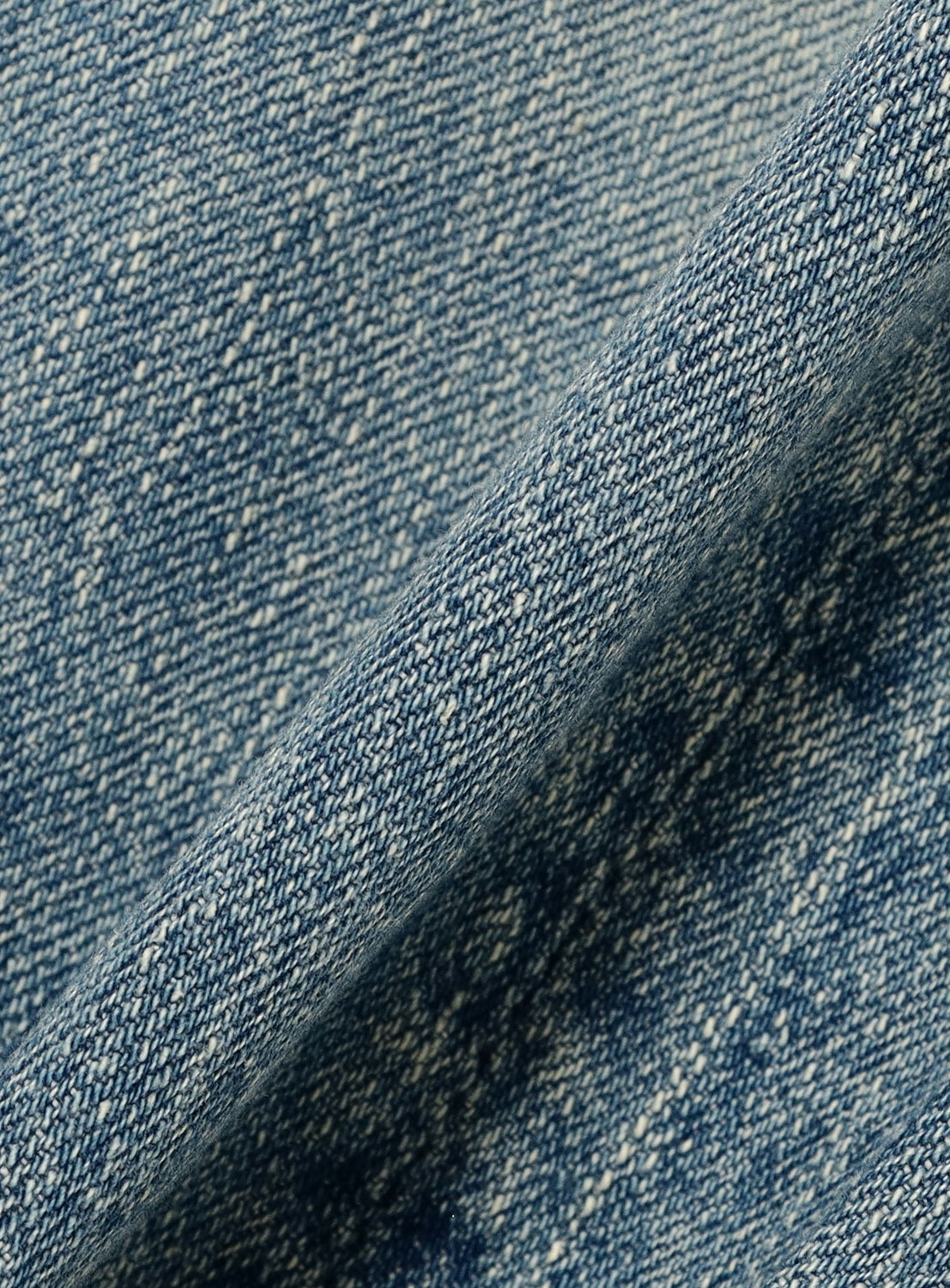 Close-up of blue denim fabric with a subtle pattern