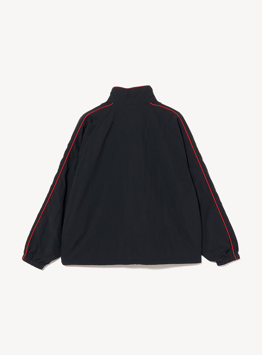 A BEAMS T Tyrrell Winston Anorak Jacket in black, designed with a high collar and long sleeves, showcases bold red piping along the shoulders and sleeves. Displayed flat with the back facing up, this piece captures the iconic style of vintage training wear.