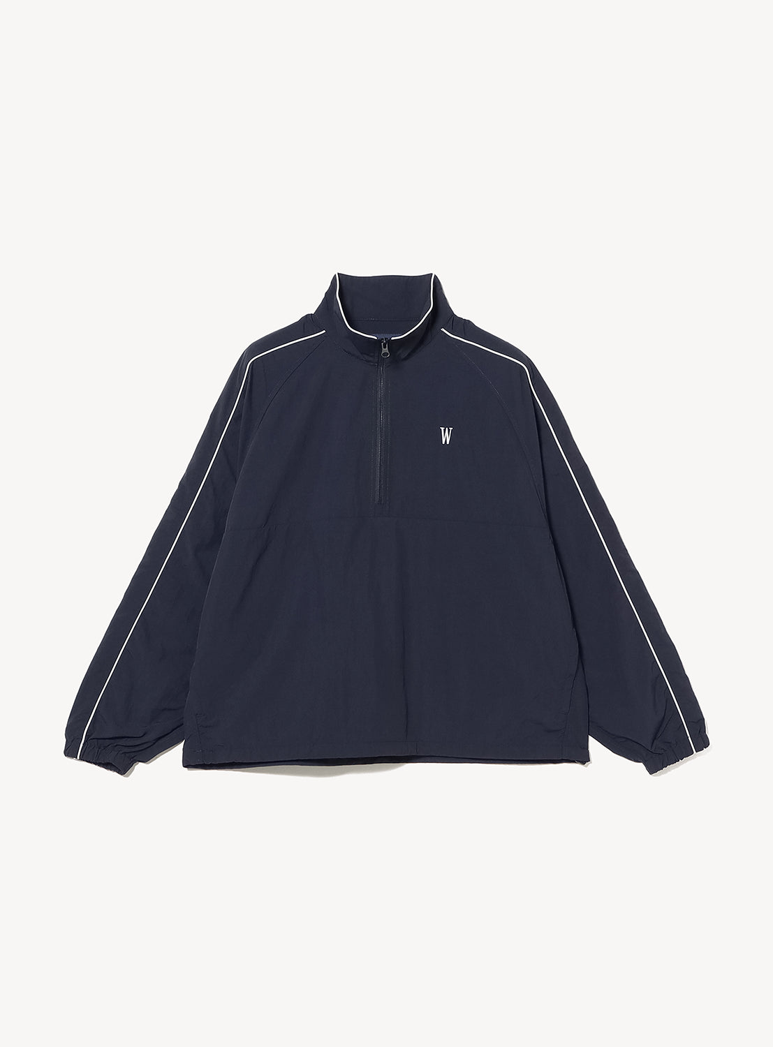 The BEAMS T Tyrrell Winston - Anorak Jacket is a navy blue pullover with a quarter-zip front, white piping along the sleeves, a stand-up collar, elastic cuffs, and a small white WIN SPORT logo on the left chest—an elevated take on vintage training wear.