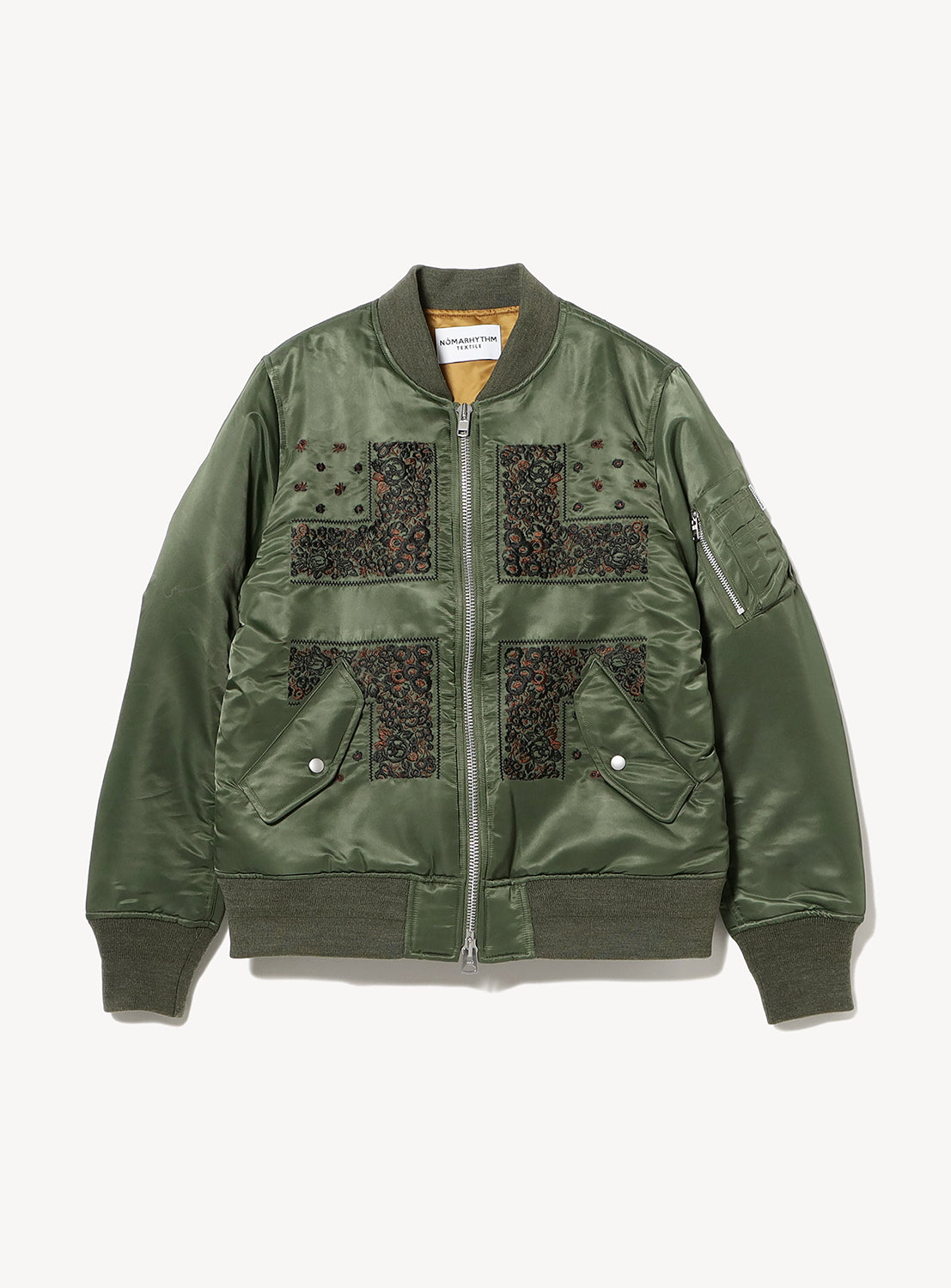 The Bandana Embroidered Flight Jacket by NOMARHYTHM TEXTILE features an olive green design with ribbed cuffs and hem, snap pockets, a zip sleeve pocket, and black floral cross embroidery; made in Japan.