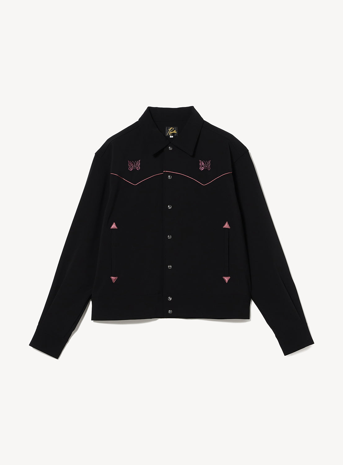 NEEDLES Piping Cowboy Jacket: a black boxy western jacket featuring a pointed yoke, pink piping, snap-button closure, and papillon embroidery motifs on the chest.
