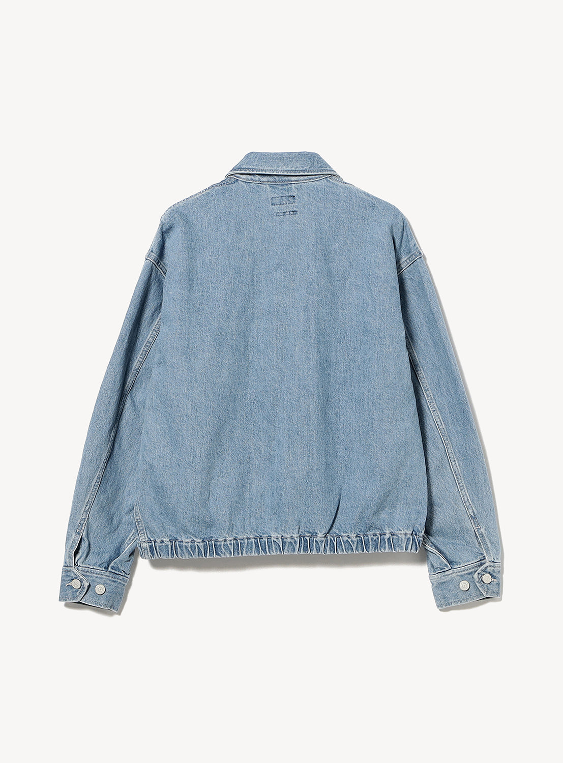 Back view of a BEAMS Nep Denim Zip Jacket, a vintage-inspired nep denim blouson with a collared neckline, long sleeves with button cuffs, and a gathered elastic hem.