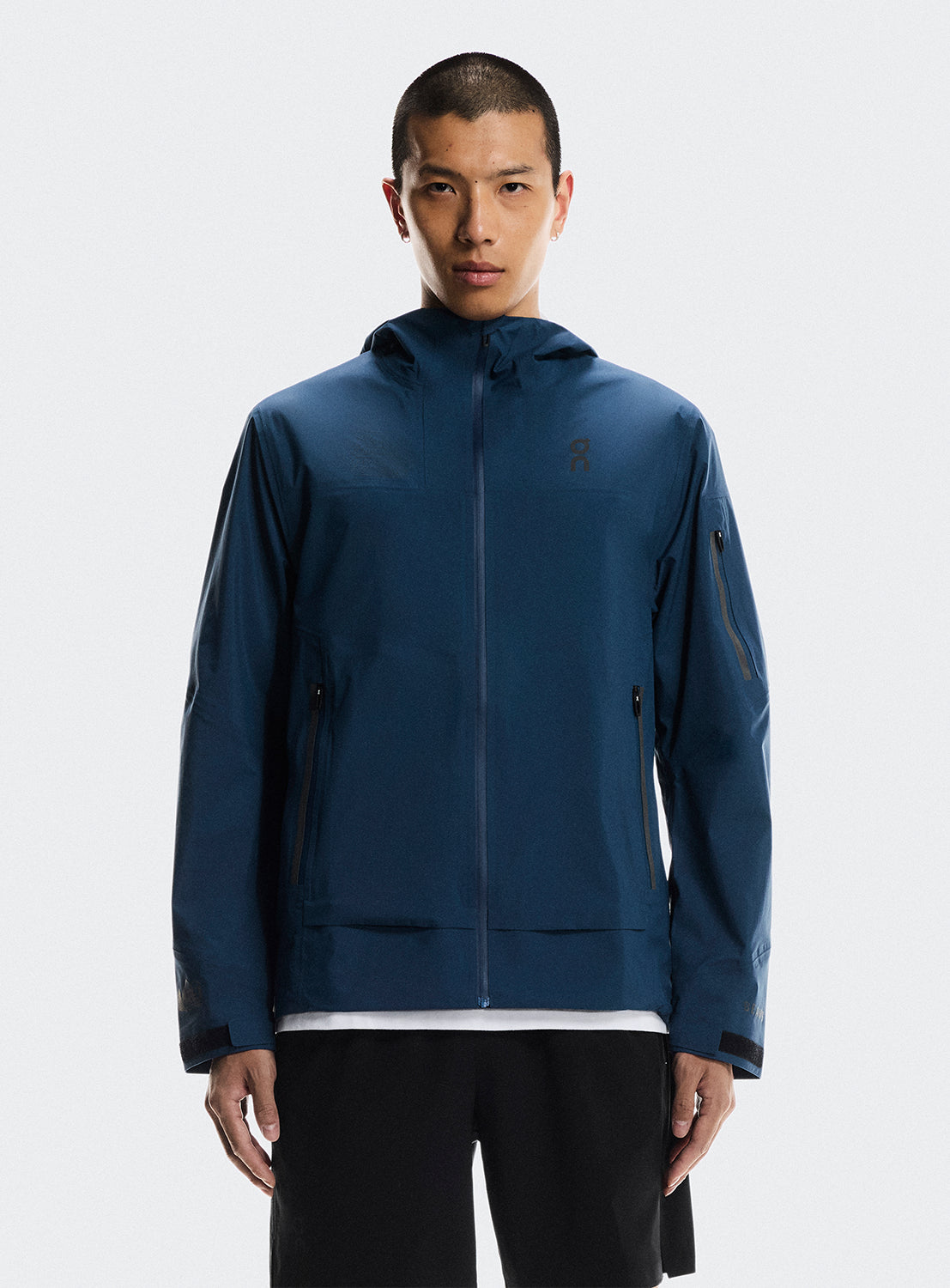 Man wearing a blue trek zip-up jacket with multiple zippers. 