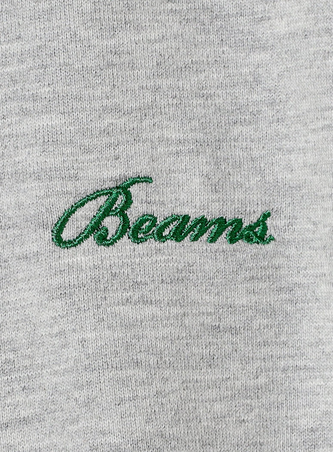 Embroidered 'Beams' logo on a gray fabric background
