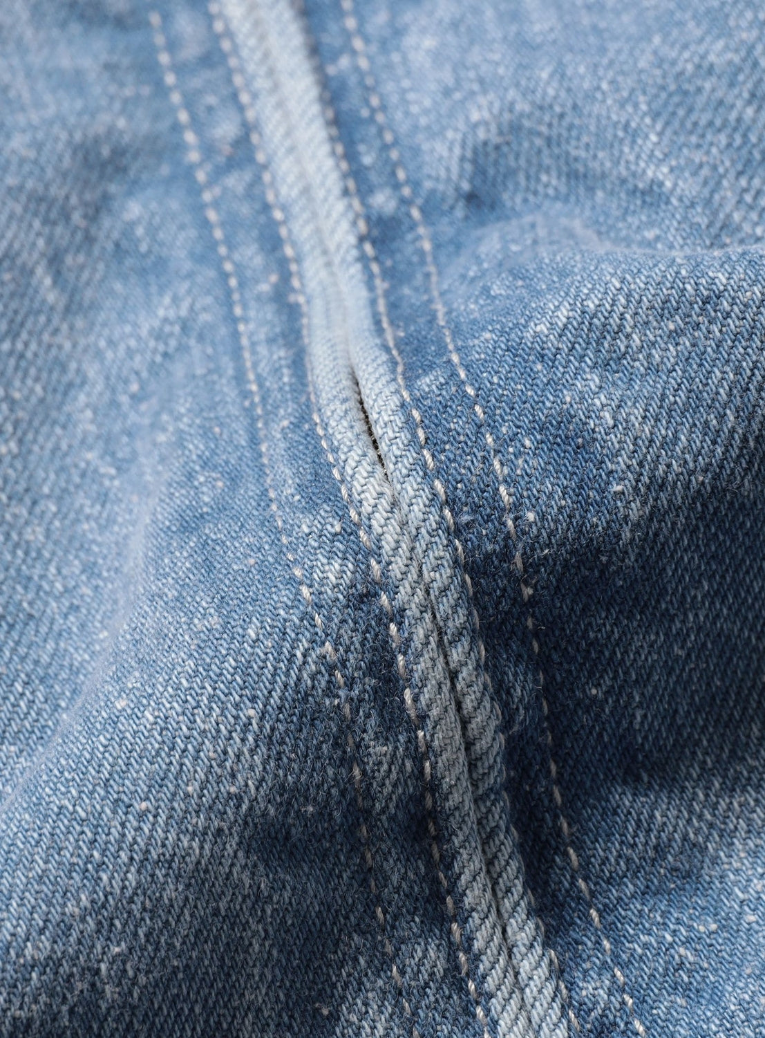 Close-up of a blue nep denim seam with visible white stitching on a BEAMS Nep Denim Zip Jacket.