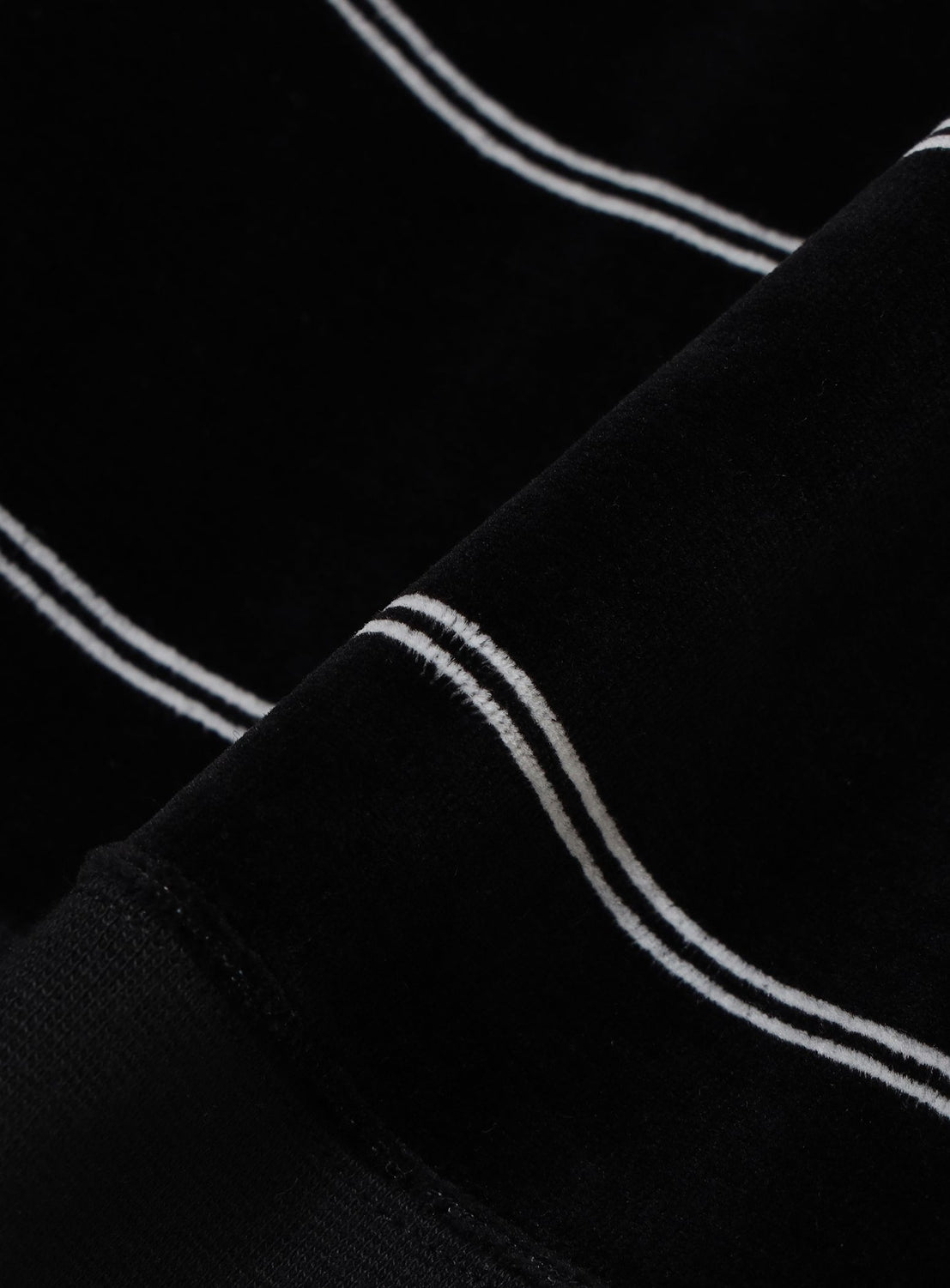 Close-up of a wide-fit BEAMS Striped Velvet Polo Shirt in black with thin white horizontal stripes.