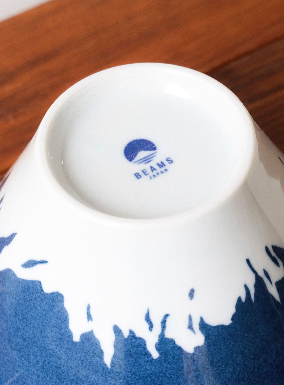 Close-up of a white ceramic bowl with blue patterns on a wooden surface
