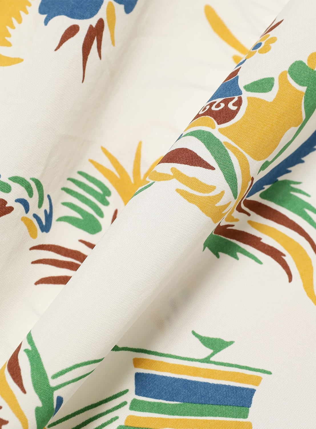 A close-up of the SUN SURF Exclusive Patchwork Aloha Shirt 26SS shows white fabric with colorful abstract yellow, green, blue, and brown shapes and lines, vintage-inspired patterning, and visible folds highlighting its texture.