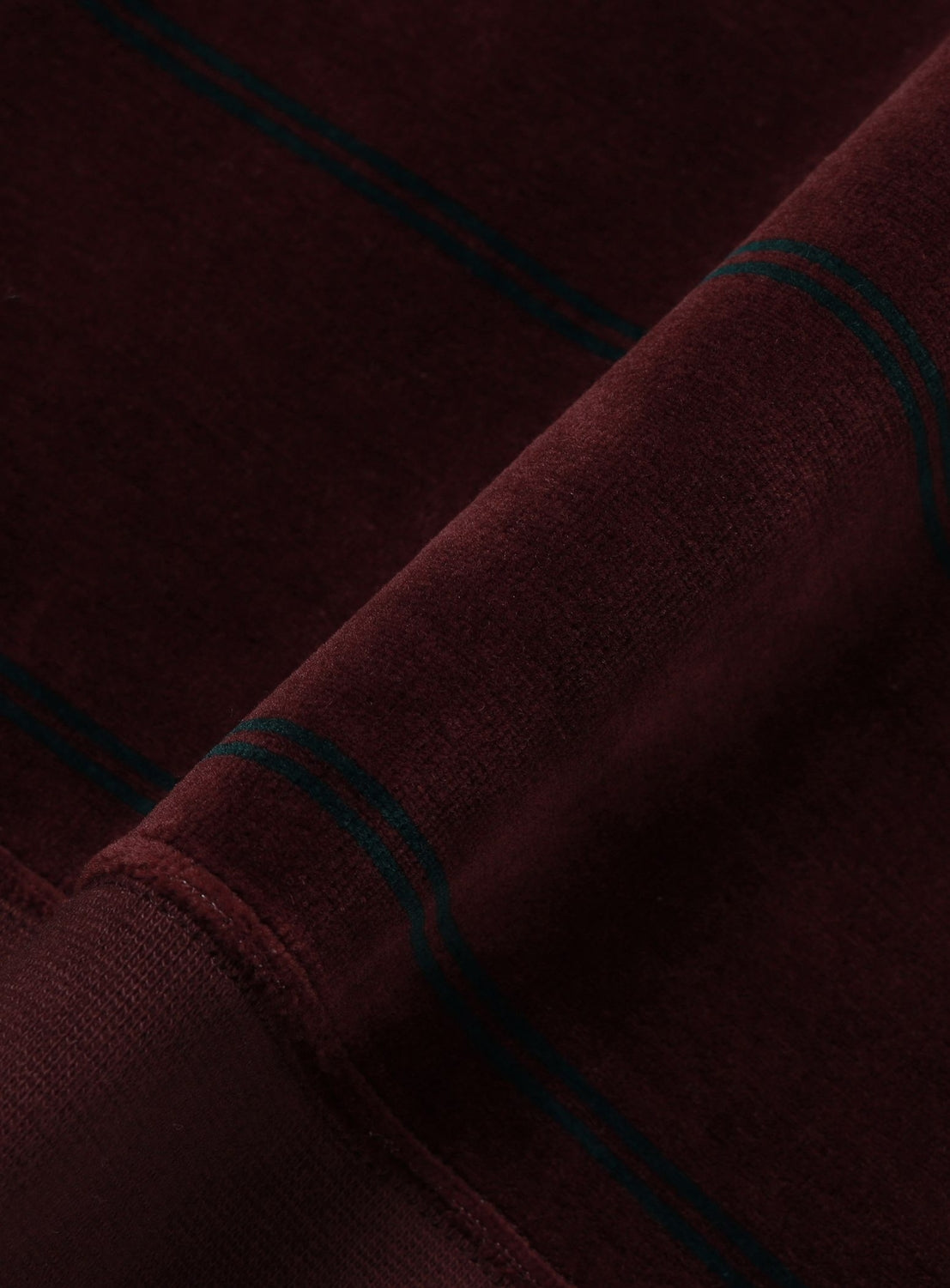 Close-up of a maroon, wide fit BEAMS Striped Velvet Polo Shirt featuring dark green horizontal stripes.