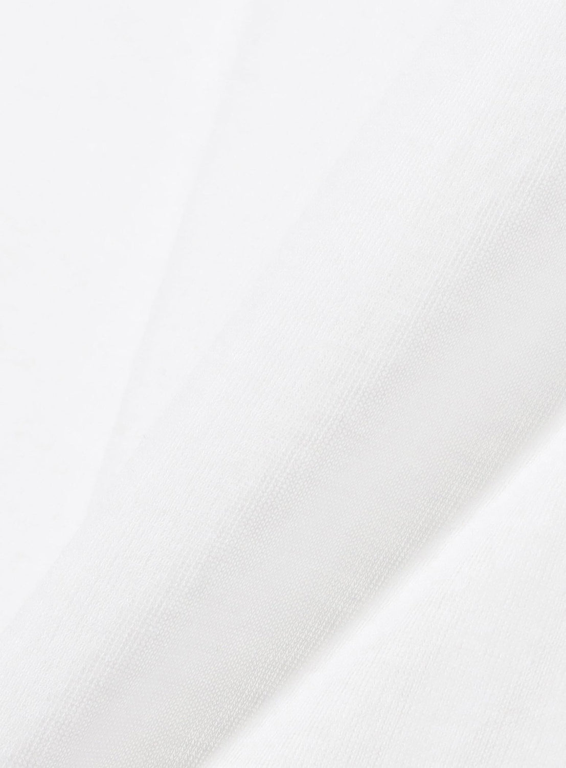 Close-up of the Ernie Palo Sheer V-Neck Cardigan’s soft, white fabric, featuring subtle diagonal folds and a smooth texture that evoke its lightweight, sheer finish.