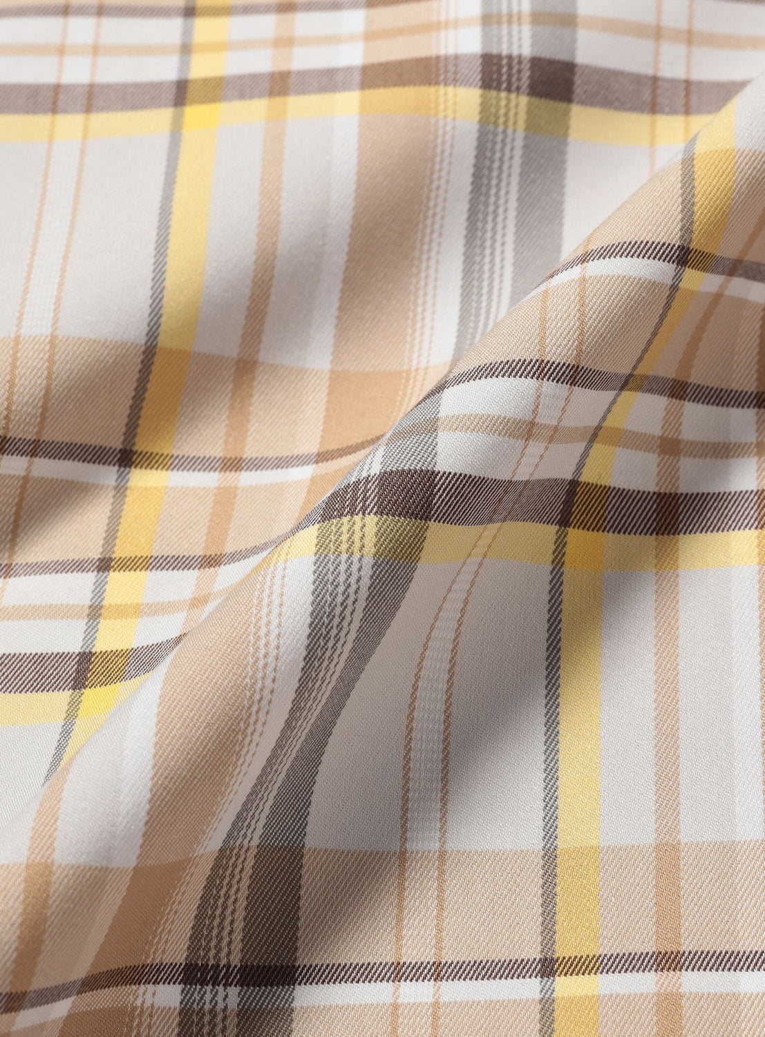 A close-up of BEAMS' Tartan Plaid Wide Zip Jacket fabric, showcasing a fold in the material and its beige, brown, white, and yellow plaid pattern.